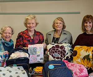Photo of women holding quilts. Links to Closely Held Business Stock